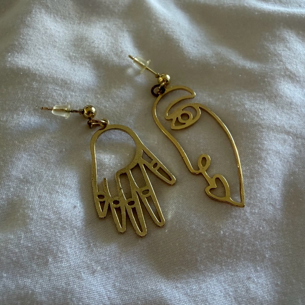 Face and hand mismatched earring set